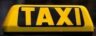 Bright yellow taxi sign on top of a vehicle, symbolizing public transportation.